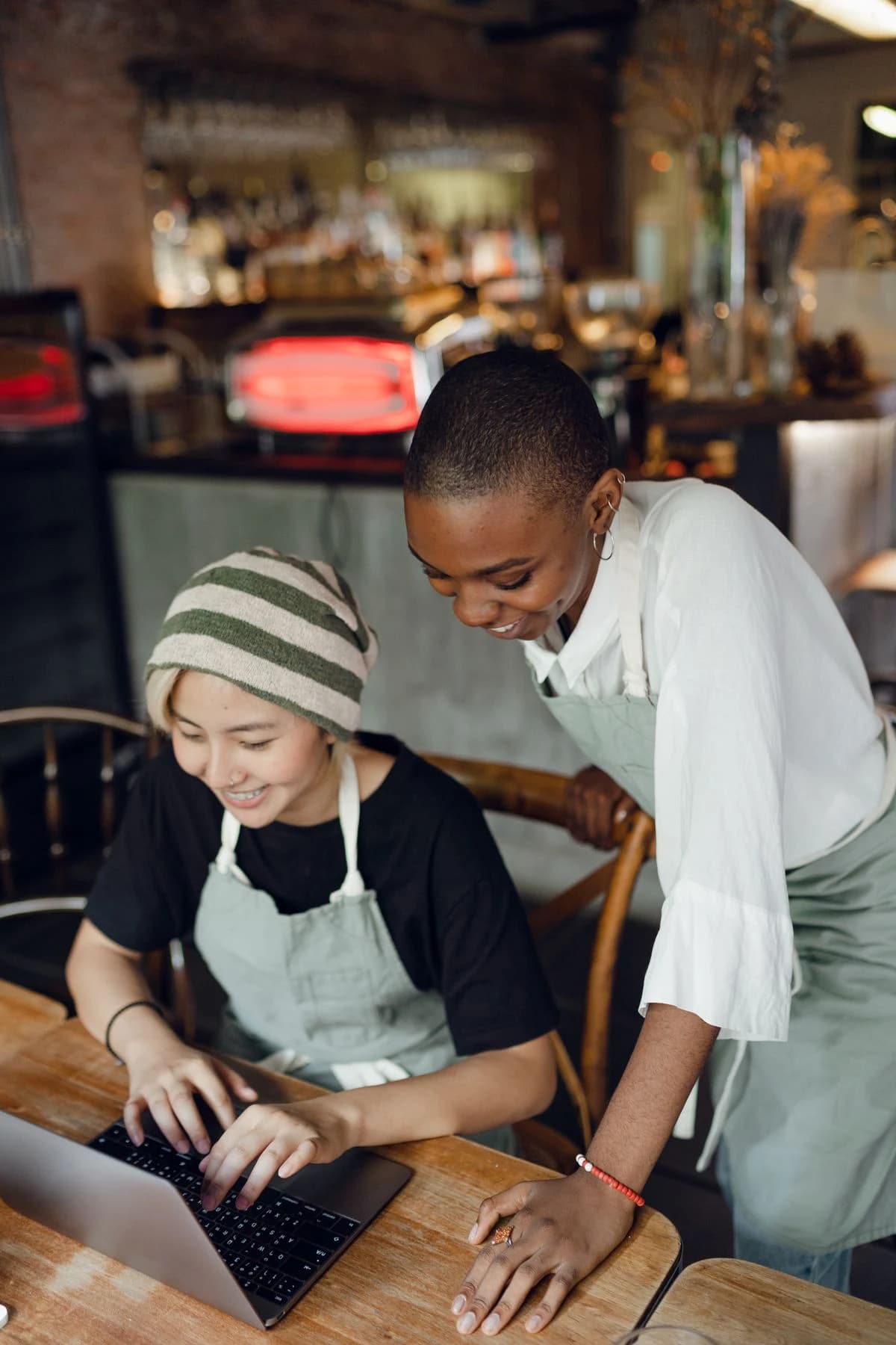 Two café colleagues reviewing a laptop together
